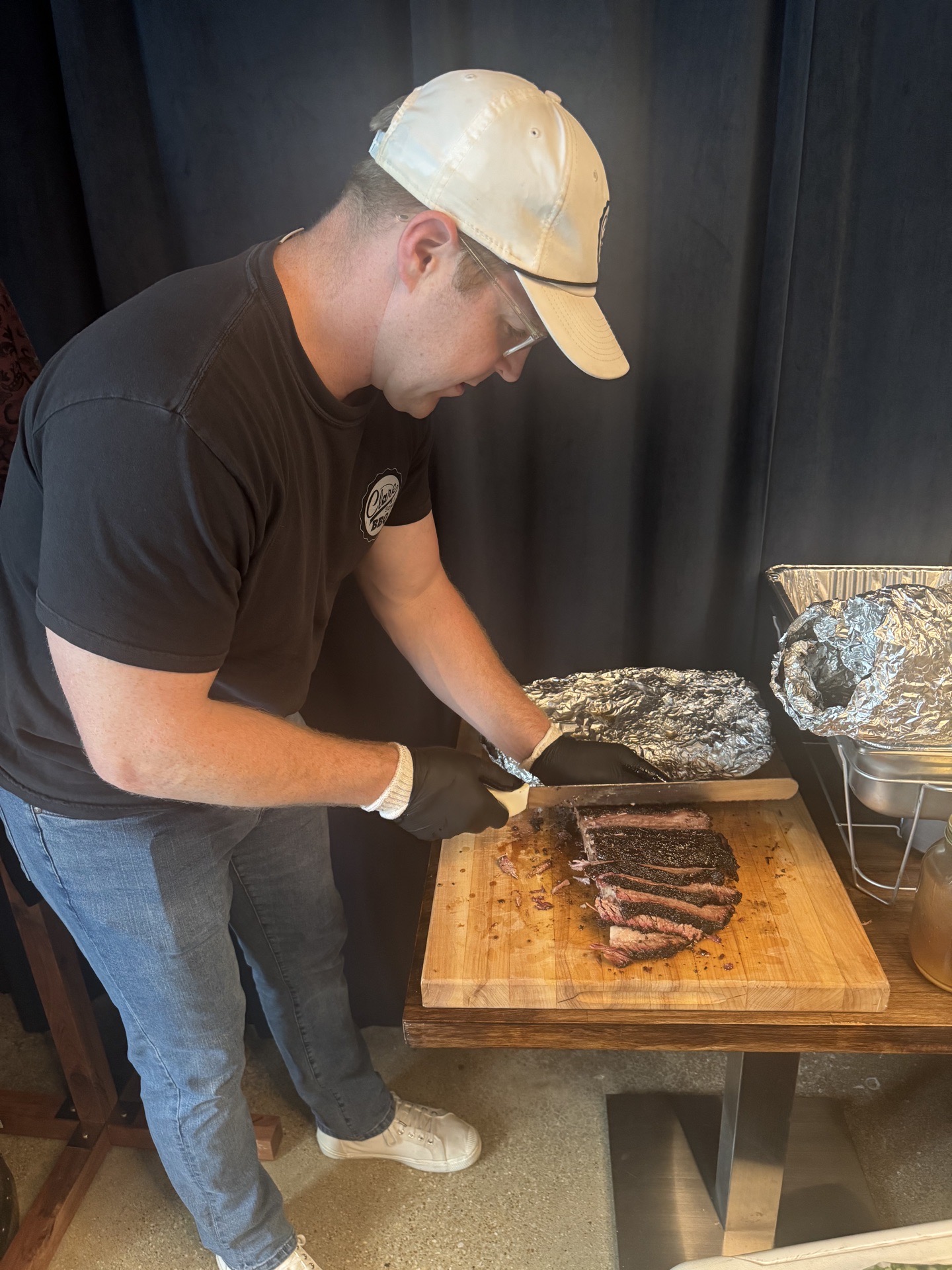 Slicing smoked brisket at a Full Proof Society gathering